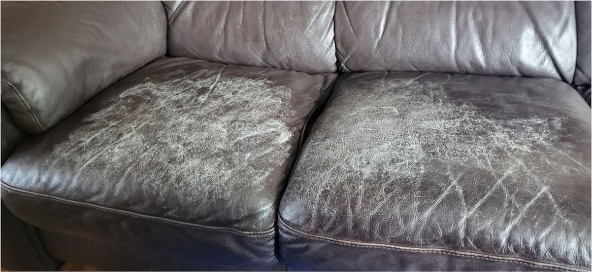 Brown leather sofa cushions covered in cracked, flaking finish before repair