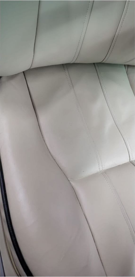 The same cream leather seat after cleaning and restoration, with an even finish