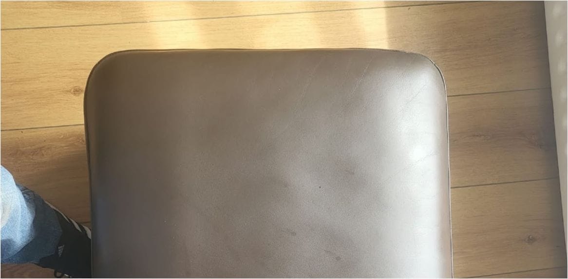 The same leather chair seat pad after colour repair, showing an even taupe finish
